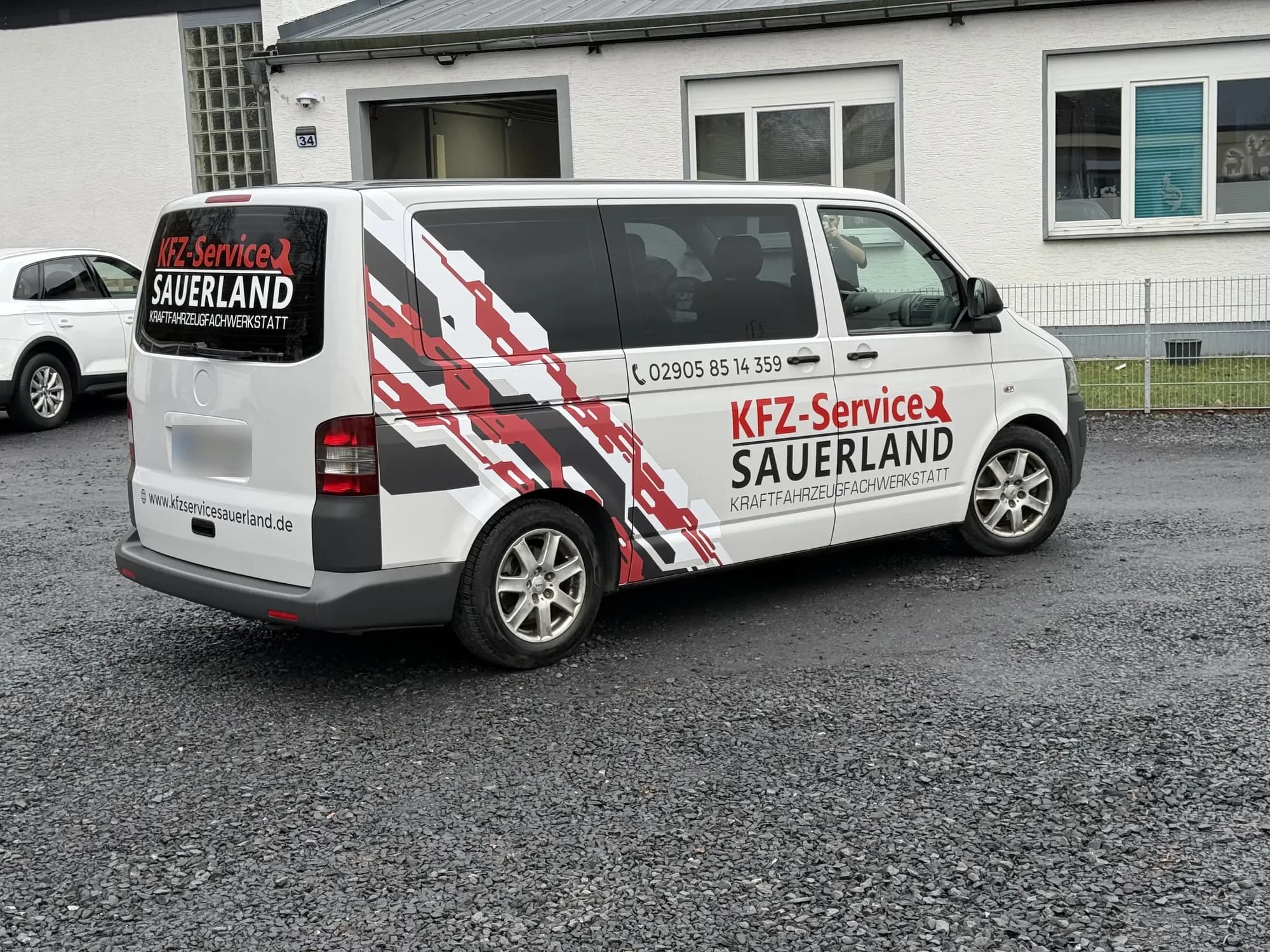 Weißer Transporter mit rot-schwarzer Beschriftung von KFZ-Service Sauerland